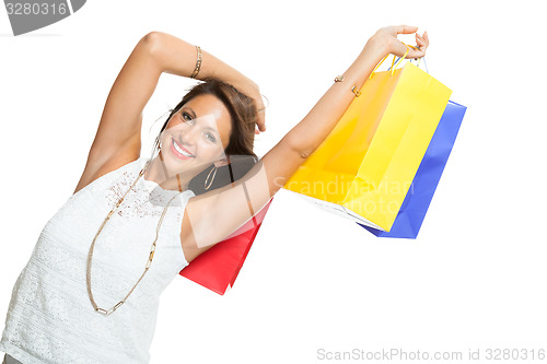 Image of Happy Woman Raising Colored Shopping Bag