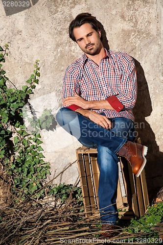 Image of Male model sitting with legs crossed