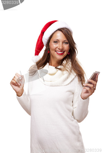 Image of Pretty woman in a Santa hat reading an sms