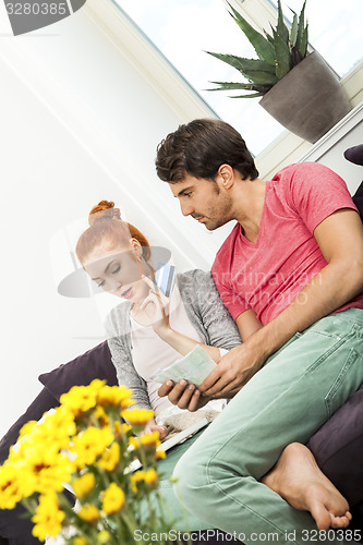 Image of Couple at the Couch with Laptop, Card and Money