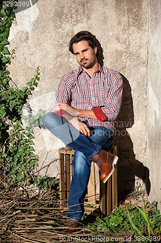 Image of Male model sitting with legs crossed