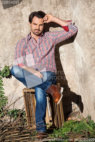 Image of Male model sitting with legs crossed