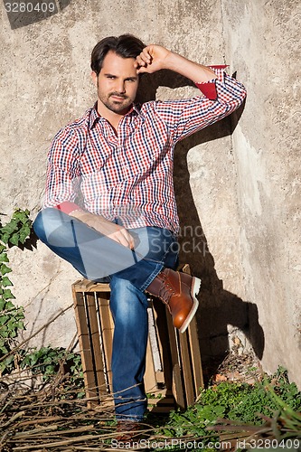 Image of Male model sitting with legs crossed