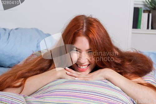 Image of Blond Woman Leaning on her Hand on a Pillow