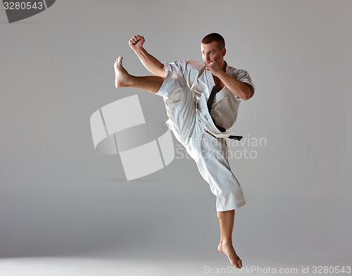 Image of Man in white kimono training karate