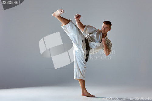Image of Man in white kimono training karate