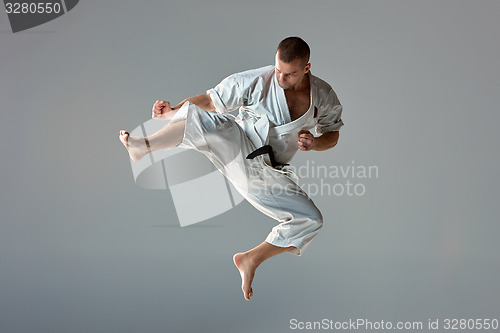 Image of Man in white kimono training karate