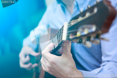 Image of Young musician playing at acoustic guitar