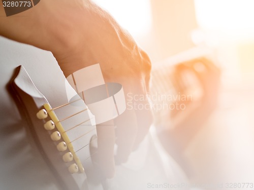 Image of Male hand playing on acoustic guitar. Close-up.