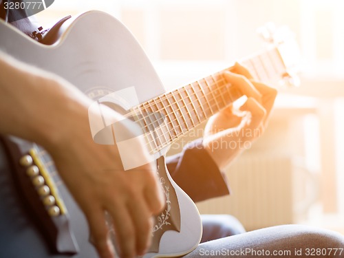 Image of Male hand playing on acoustic guitar. Close-up.