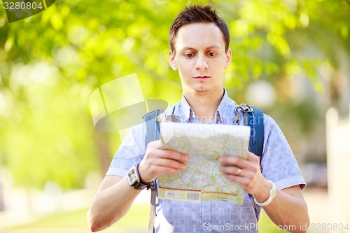 Image of Young man with a map outdoors