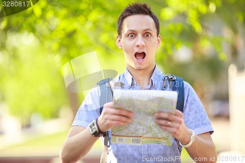 Image of Young man with a map outdoors