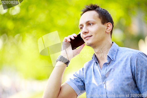 Image of handsome young man talking on the cell phone
