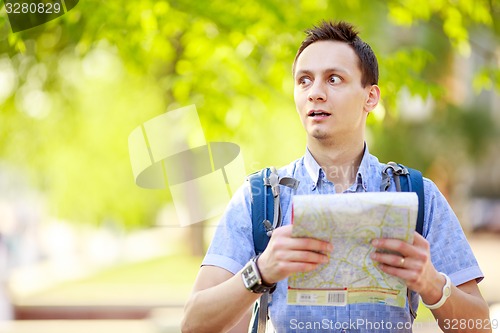 Image of Young man with a map outdoors