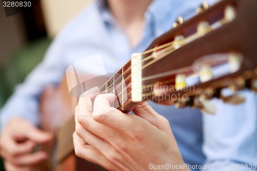 Image of Young musician playing at acoustic guitar