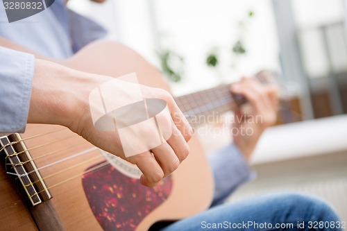 Image of Man playing classic, acoustic guitar