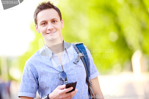 Image of Close up portrait of a young man with phone