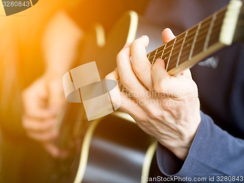 Image of Male hand playing on acoustic guitar. Close-up.