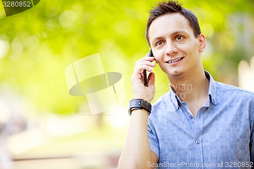 Image of handsome young man talking on the cell phone