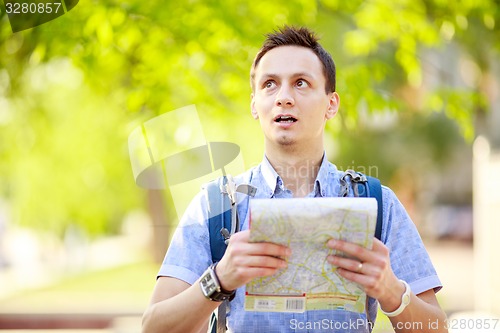 Image of Young man with a map outdoors