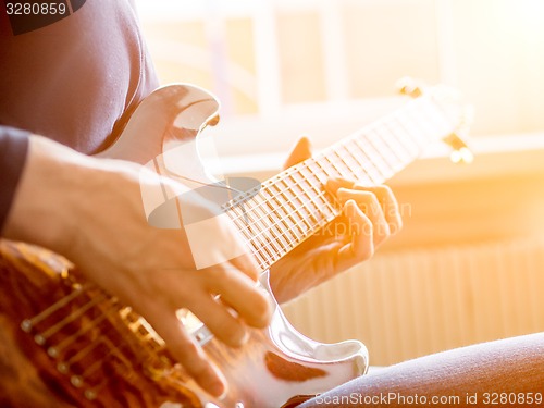 Image of Male hand playing on acoustic guitar. Close-up.