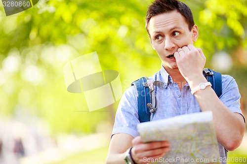 Image of Young man with a map outdoors