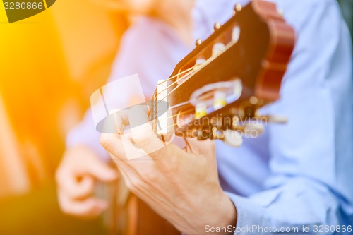 Image of Young musician playing at acoustic guitar