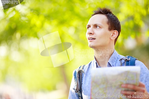 Image of Young man with a map outdoors