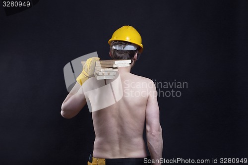 Image of Carpenter carrying wooden planks