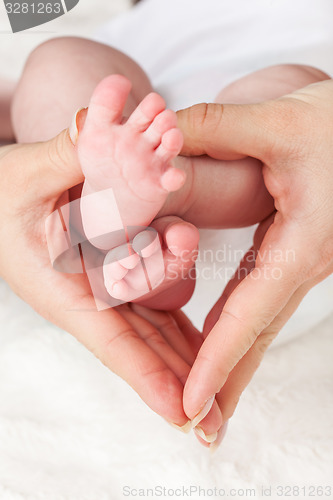 Image of Mother holding newborns feet