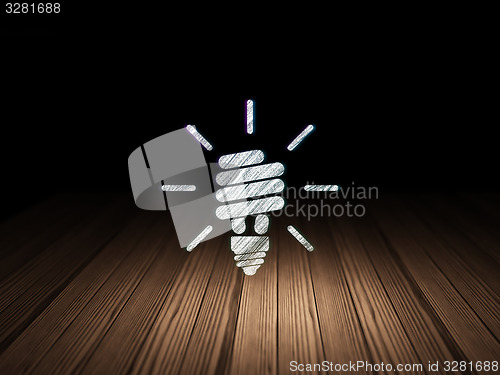 Image of Finance concept: Energy Saving Lamp in grunge dark room