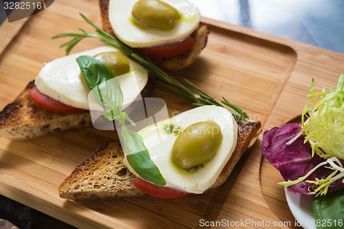 Image of Bruschetta with tomato, mozarella and olive