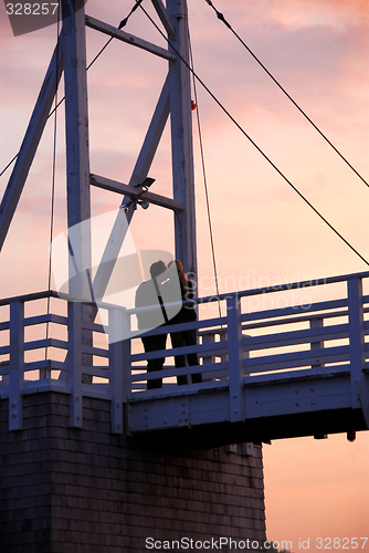 Image of Couple kissing on a bridge