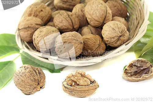 Image of fresh walnuts with walnut leaves in a basket