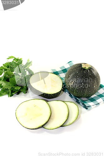 Image of rotund raw zucchini on a checkered napkin