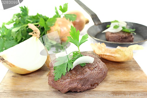 Image of Ostrich steak with onions and parsley