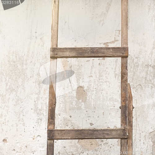 Image of weathered stucco wall with wooden ladder