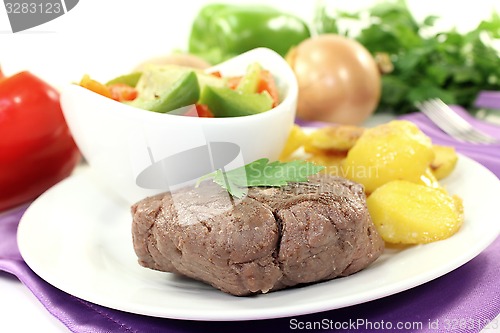 Image of Ostrich steaks with baked potatoes and parsley