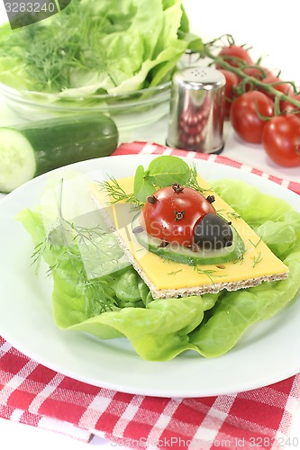 Image of Crispbread with cheese, lettuce and ladybug