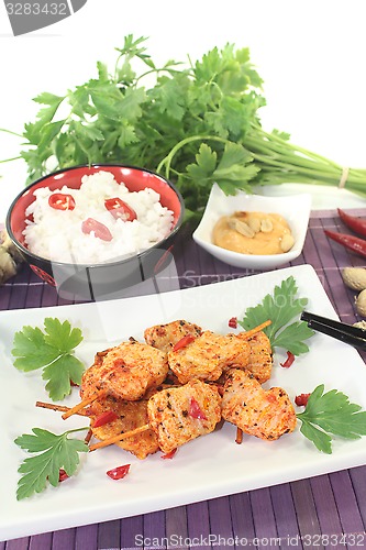 Image of Asian satay skewers with rice and parsley