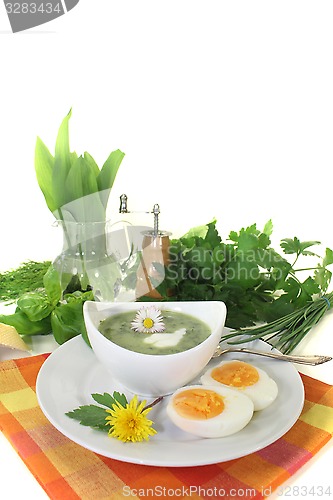 Image of green herb soup with eggs and a dollop of cream