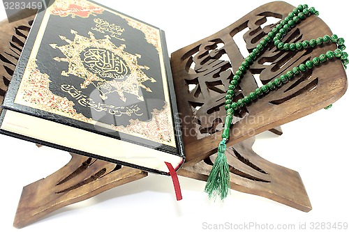 Image of stand with Quran and green rosary