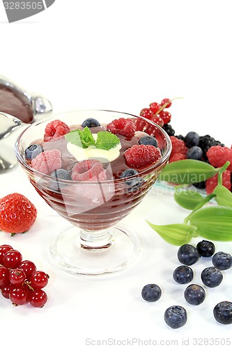 Image of red fruit jelly with custard and vanilla leaves