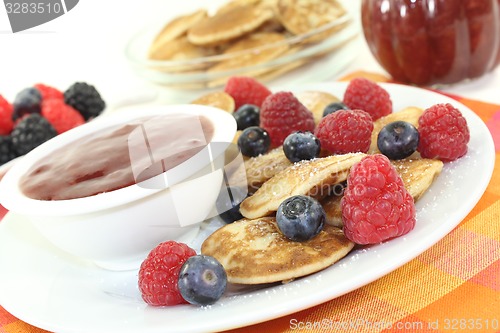 Image of Poffertjes with berries and icing sugar