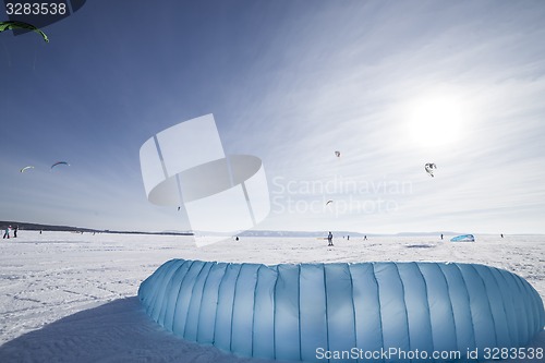 Image of Kiteboarder with blue kite on the snow