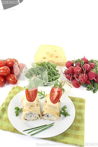 Image of stuffed cheese crepe rolls with arugula