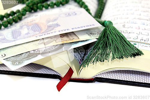 Image of whipped Quran with Egyptian currency