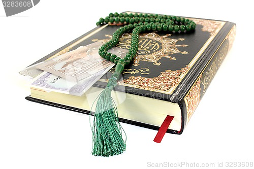 Image of slammed Quran with Pakistani currency