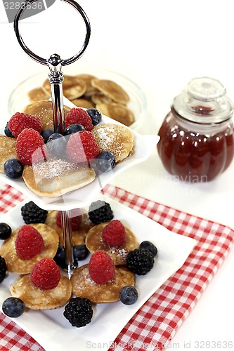 Image of Poffertjes with berries and jelly on a cake stand