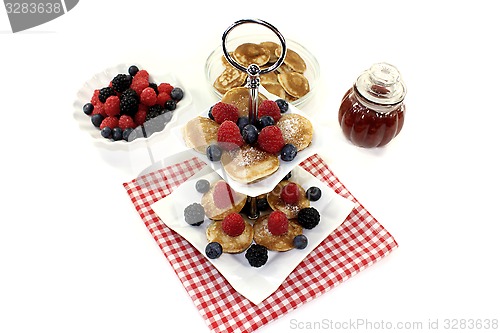 Image of Poffertjes with raspberries on a cake stand